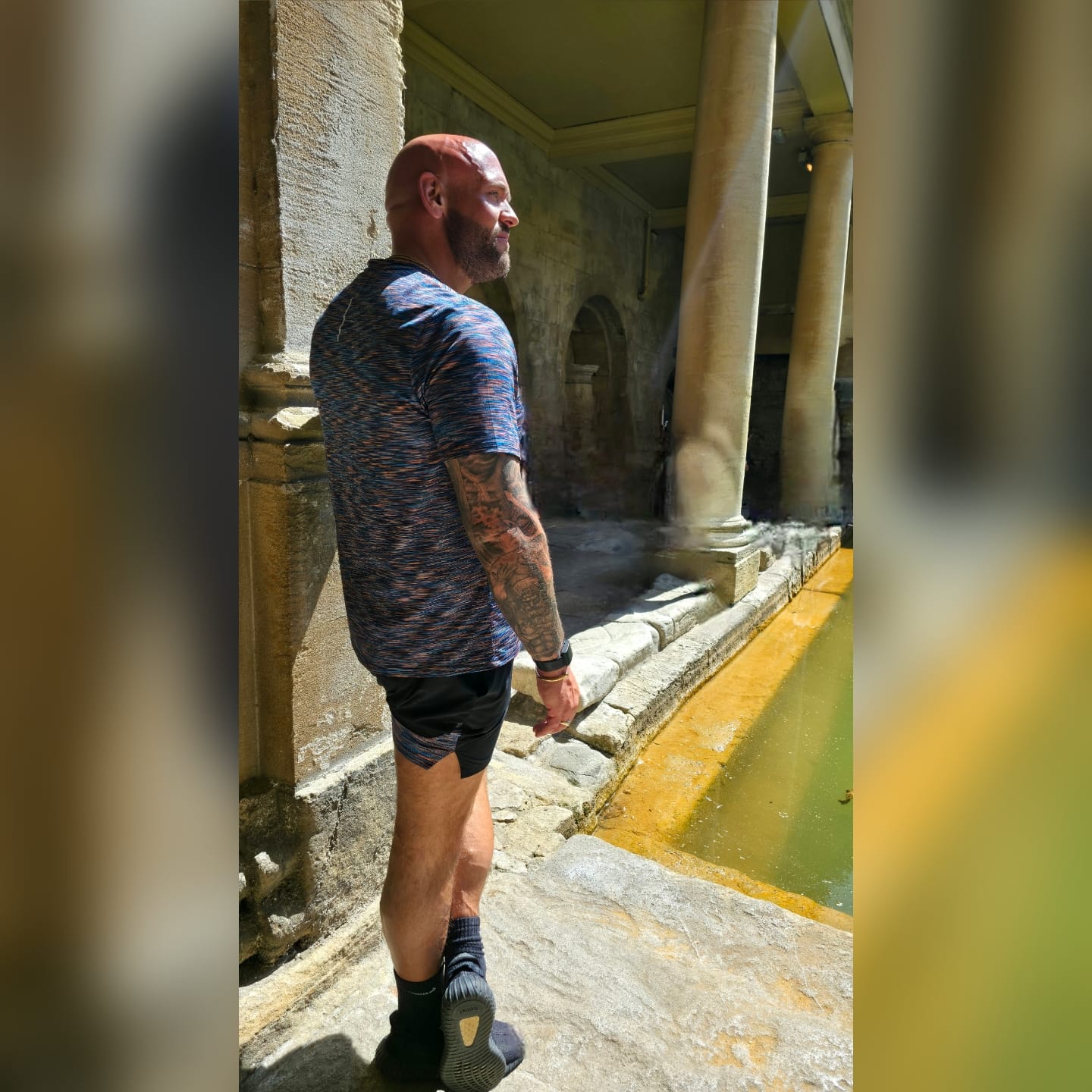 Jeff Charles standing beside stone columns in sunlight